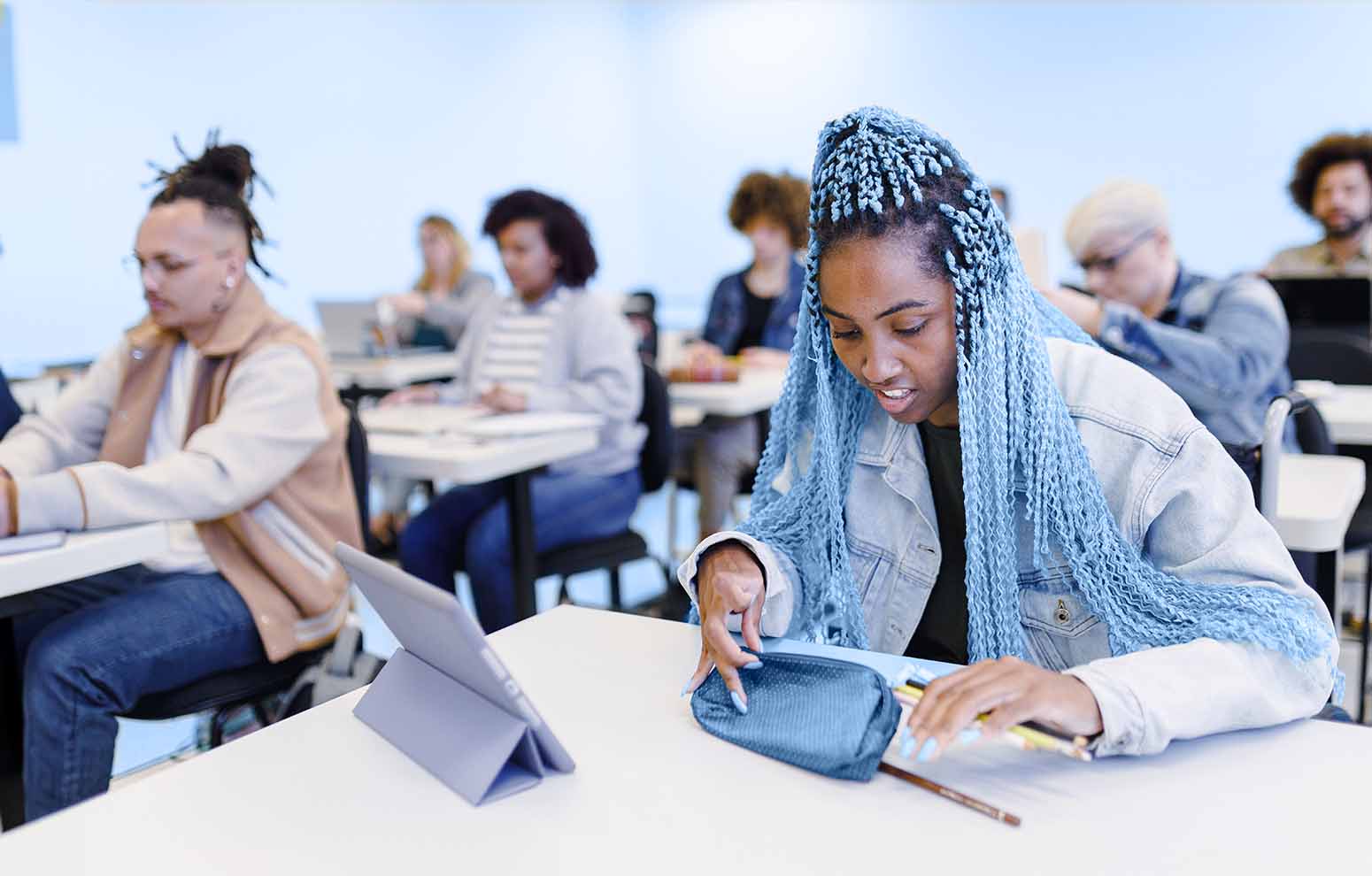 Girl with blue braids at classroom desk